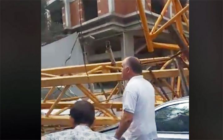 Bakıda qaldırıcı kran yaşayış binasının və maşınların üstünə aşıb