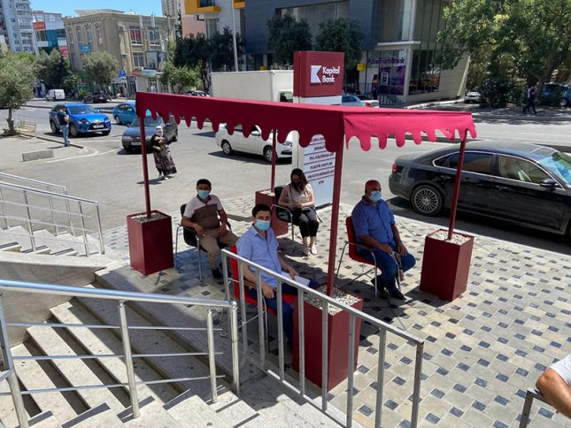 Kapital Bank filialların önündə müştəriləri günvurmadan qoruyur